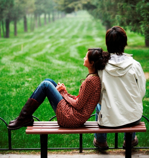 Young Couple Relaxing on Park Bench
